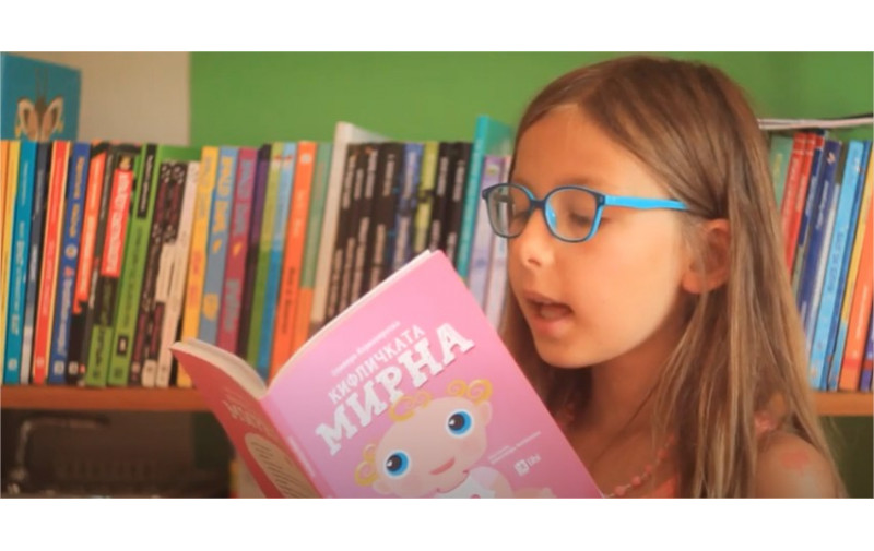Марија ја чита книгата Кифличката Мирна од Оливера Ќорвезироска
