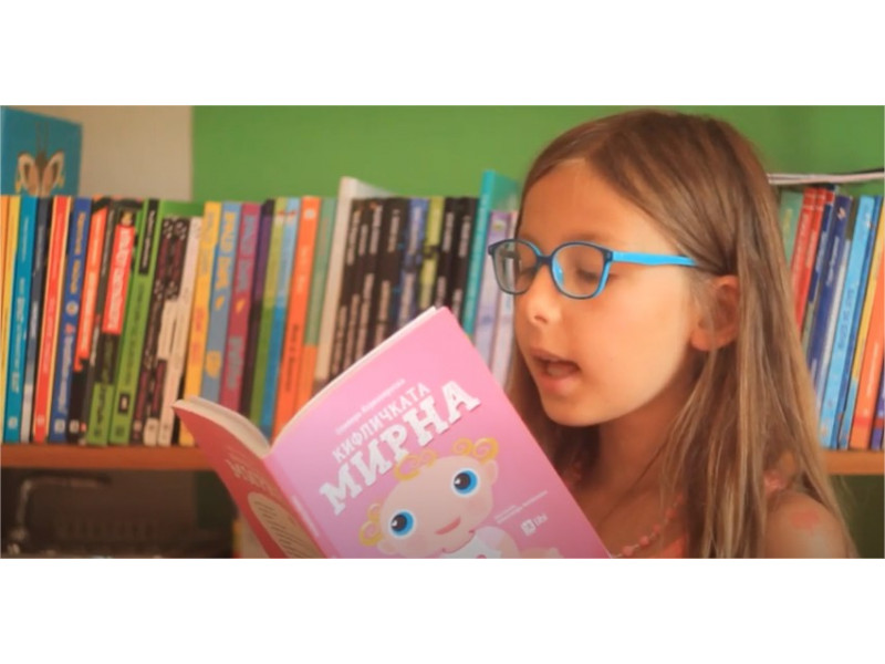 Марија ја чита книгата Кифличката Мирна од Оливера Ќорвезироска